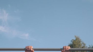 Kaslı atletik genç adam yatay çizgide barfiks çekiyor. Spor ve sağlık konsepti 