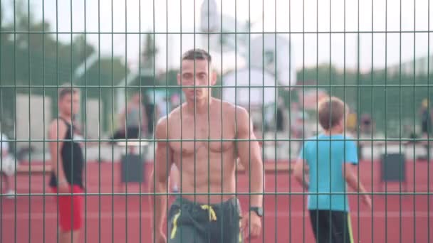 Sportlicher Junger Mann Der Mit Einem Ball Über Den Basketballplatz — Stockvideo