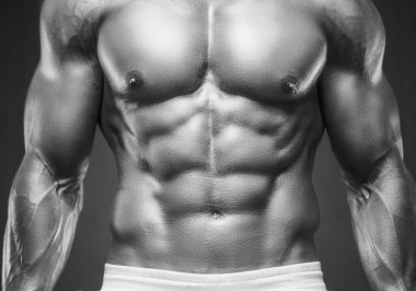 Spor salonunda kaslarını şişiren genç bir atletik. Spor ve sağlık geçmişi