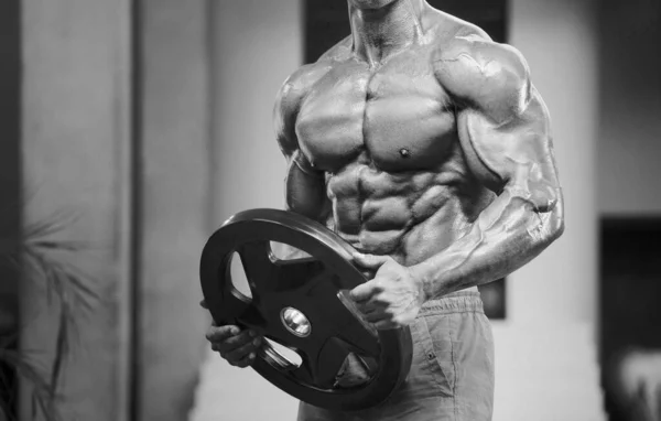 Hombre Atlético Joven Bombeando Los Músculos Gimnasio Entrenamiento Fondo Del —  Fotos de Stock