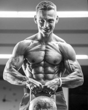 Spor salonunda kaslarını şişiren genç bir atletik. Spor ve sağlık geçmişi