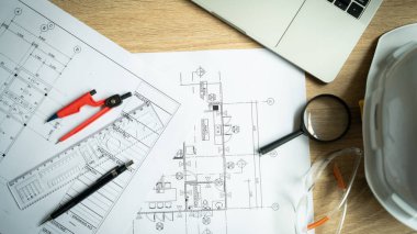 Üzerinde büyüteç ve güvenlik gözlüğü olan bir bina çizimi.