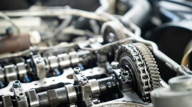 Zincirli ve vitesli bir araba motoru. Motor kirli ve üzerinde çok fazla yağ var.