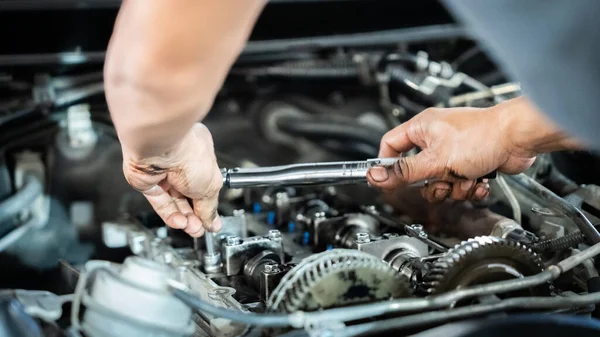Bir tamirci bir araba motoru üzerinde çalışıyor. Odaklanma ve kararlılık kavramı. Tamirci motoru dikkatlice inceleyip tamir ediyor. Sahne, tamircinin yetenekli olduğunu gösteriyor.