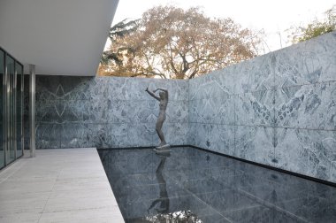 Bir köşede Georg Kolbe tarafından kadın heykeli ve ludwig Mies van der Rohe tarafından sığ yansıtan havuz Barcelona Pavilion ile Veranda