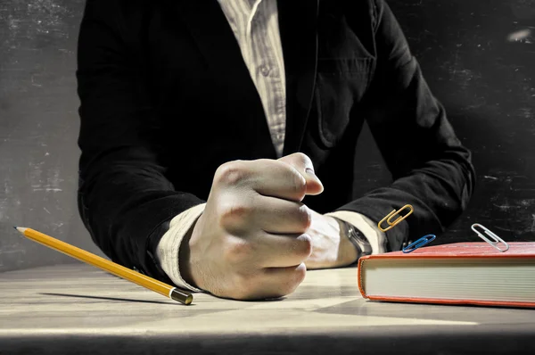 Table with mans fist. Scratched, dark  background. — Stock Photo, Image