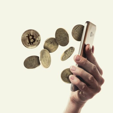 Akıllı telefon ekranından Bitcoin paraları düşüyor.