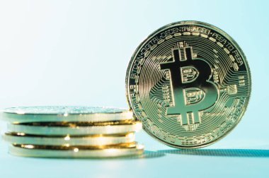 Mavi arkaplanda Bitcoin sikkeleri.
