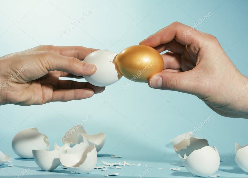 Intact golden egg among broken white eggs. The concept of reliability, resistance to adverse conditions.
