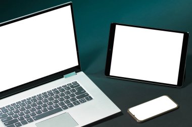 Akıllı telefon, dijital tablet ve dizüstü bilgisayarla yeşil arkaplandaki tasarımınız için beyaz ekranlar ayarlayın.