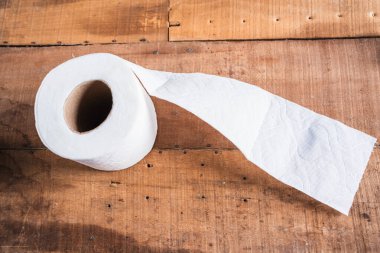 Eski ahşap bir masada eskimiş tuvalet kağıdı.