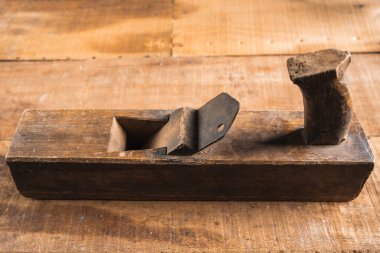 Eski ahşap bir kat, ahşap bir uçak, kerpeten ve tesisat hattı gibi antika inşaat aletleri izole edilir ve kahverengi ahşap bir duvarda antika bir tılsım sergilenir..