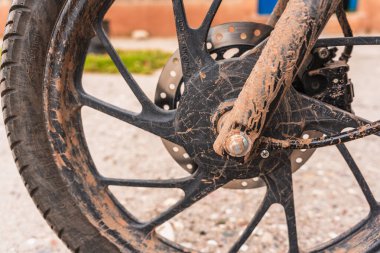 Bakıma ihtiyacı olan siyah, kirli, çamurlu ve paslı bir motorsikletin detaylı planları..