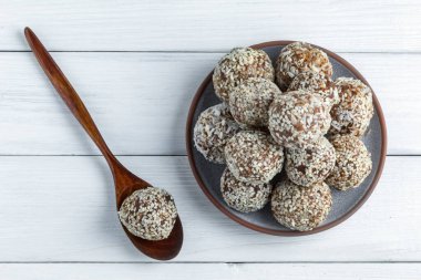 Ahşap kaşıkla beyaz arka planda No Bake Energy Balls 'a yakın çekim yapın. Üst Manzara. Yumuşak odak