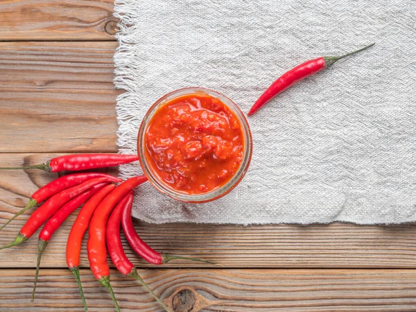 Beyaz keten havluyla kırmızı biberli cam bir Harissa kavanozunun en yakın görüntüsü. Kopyalama alanı ile.
