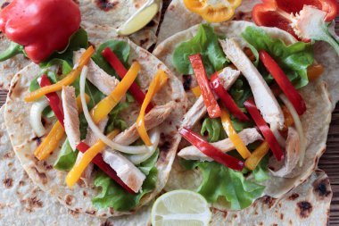 Izgara soğan, dolmalık biber ve tortilla soslu tavuk fajitaları..