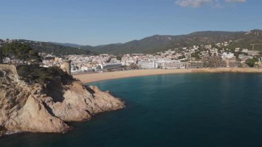 Arkasında kayalık bir uçurum olan güzel bir sahil.