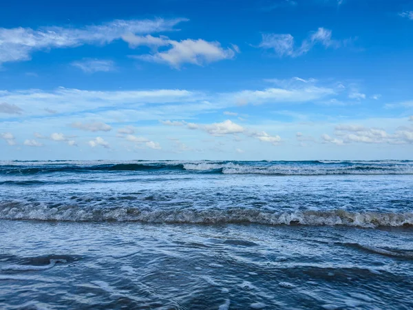 Okyanus sakin ve gökyüzü mavi. Su koyu mavi bir renktir. Gökyüzü açık ve güneş parlıyor.