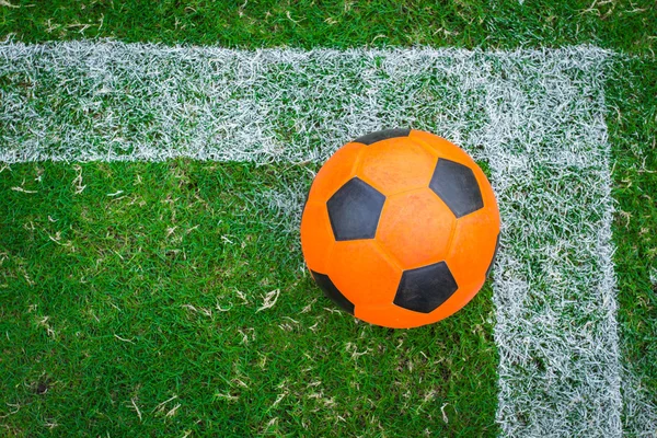 Balón de fútbol naranja en el campo verde — Foto de Stock
