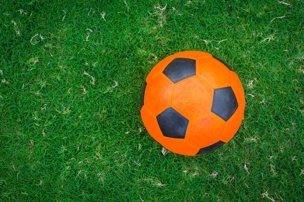 Balón de fútbol naranja en el campo verde — Foto de Stock