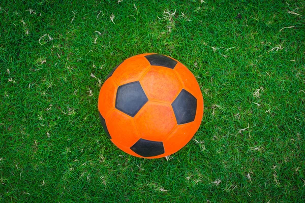 Balón de fútbol naranja en el campo verde — Foto de Stock