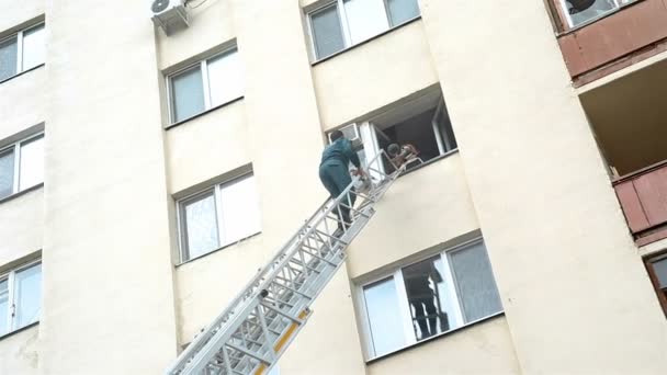 आदमी व्यक्ति को सीढ़ियों से आग से बचाता है — स्टॉक वीडियो
