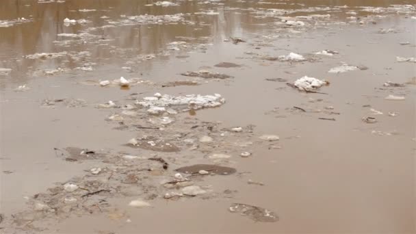 Río de manantial con agua marrón sucia y hielo. flotante de hielo — Vídeos de Stock