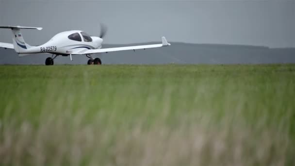 Небольшие частные самолеты на зеленом поле — стоковое видео