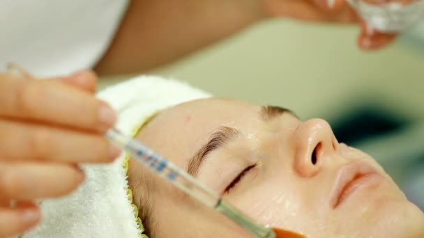 Primer plano Beautician salpicadura remedio especial en la cara con cepillo — Vídeos de Stock