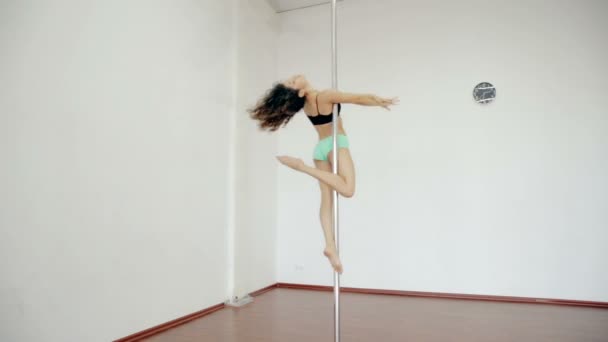 Bred skott unga flicka dansa poledance i vita rummet — Stockvideo