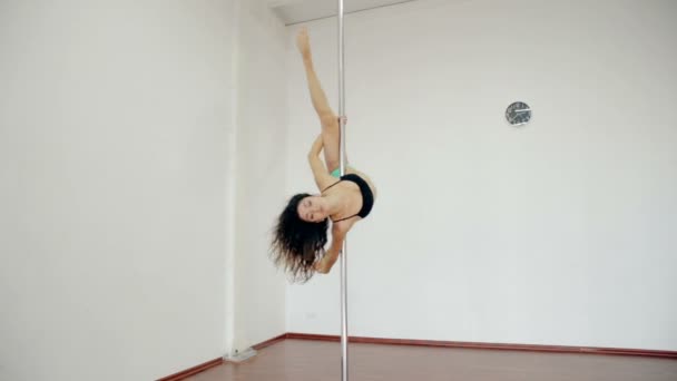 Amplo tiro Jovem dançando poledance na sala branca — Vídeo de Stock