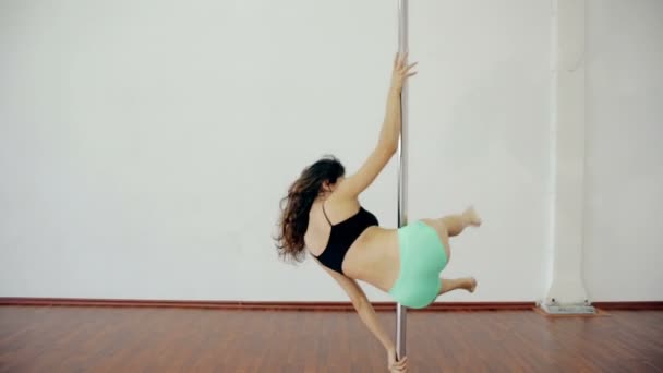 Amplio tiro Chica joven bailando poledance en habitación blanca — Vídeos de Stock