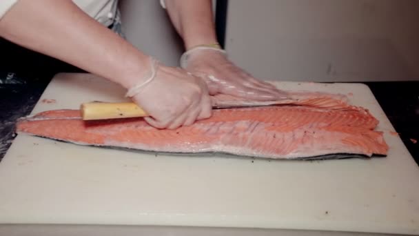 Close up tiro o cozinheiro cortar peixe vermelho fresco — Vídeo de Stock