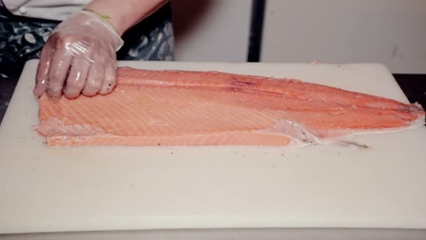 Close up tiro o cozinheiro remover ossos de peixe vermelho fresco — Vídeo de Stock