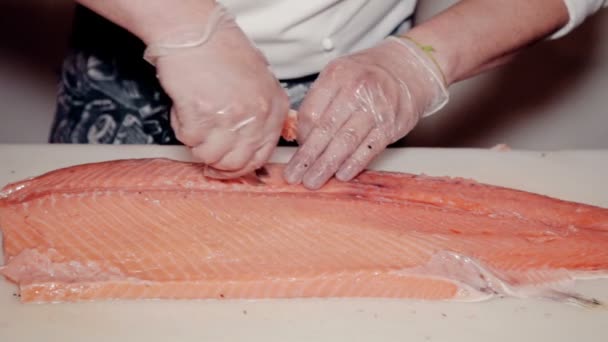 Close up tiro o cozinheiro remover ossos de peixe vermelho fresco — Vídeo de Stock