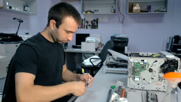 Mid shot werknemer reparaties elektronische spullen — Stockvideo