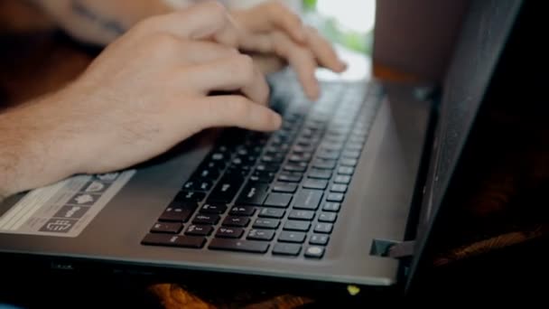 Nahaufnahme erschossener Mann arbeitet am Computer und trinkt Kaffee im Café — Stockvideo