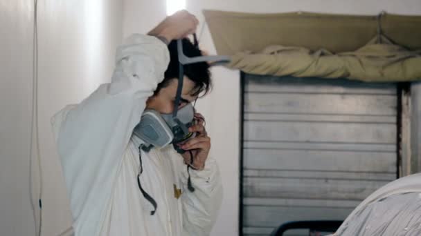 Mitten av skott arbetare sätter respirator på hans ansikte — Stockvideo