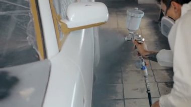 Çekim çalışan bir araba beyaz renkte boyar.