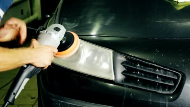 Close up shot worker polish car headlight with special tools — Stock Video