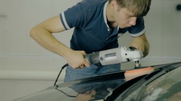 Рабочий полировать черный автомобиль со специальными инструментами — стоковое видео