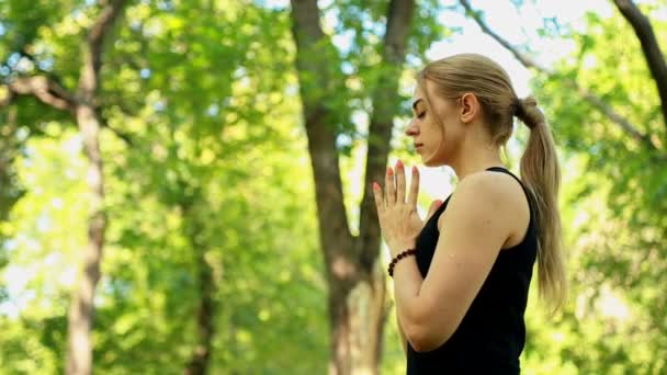 Mitten av skott ung kvinna göra yoga i parken — Stockvideo