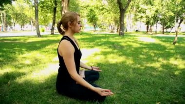 Yoga park yaparken geniş çekim genç kadın