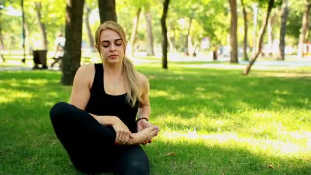 Mitten av skott ung kvinna göra yoga i parken — Stockvideo