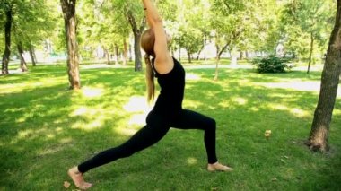 Yoga park yaparken geniş çekim genç kadın