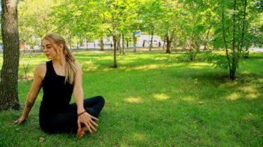 Yoga park yaparken geniş çekim genç kadın