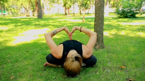 Połowie strzał młoda kobieta robi joga w parku — Wideo stockowe