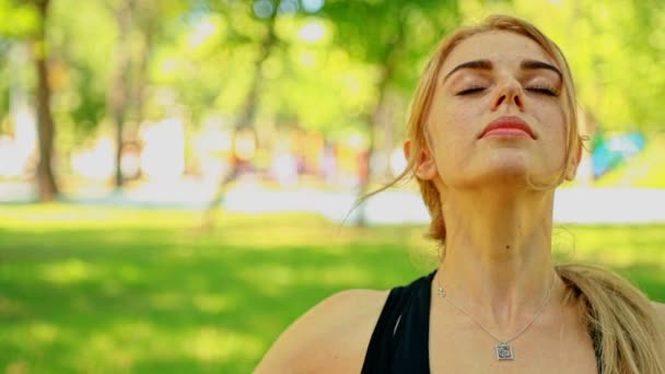 クローズ アップ ショットの若い女性が公園でヨガ — ストック動画