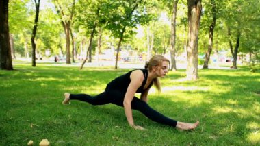 Yoga park yaparken geniş çekim genç kadın