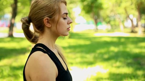 Mujer joven haciendo yoga en el parque — Vídeos de Stock